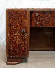 Load image into Gallery viewer, Art Deco style writing desk featuring rich, swirling burl wood grain patterns in warm brown and amber tones, with a single cabinet door and two drawers on the left side.
