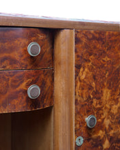 Load image into Gallery viewer, Close-up of a wooden writing desk or cabinet with two drawers on the left and a cabinet door on the right, both featuring rich brown burl wood grain and round silver metal drawer pulls.
