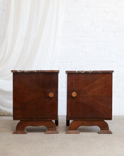 Load image into Gallery viewer, A pair of vintage mid-century wooden nightstands with marble tops and round wooden knobs, set against a white brick wall and draped white fabric.
